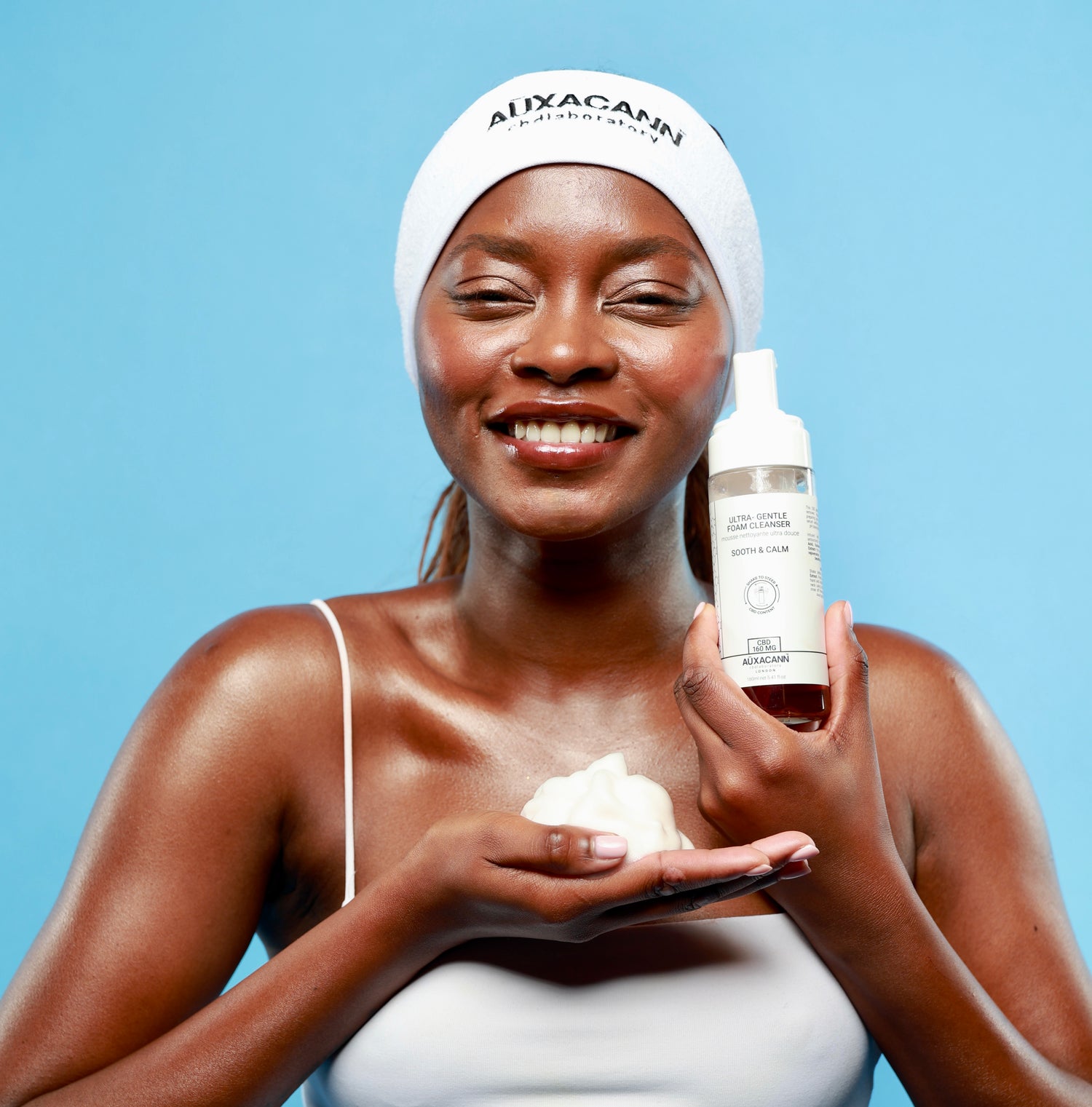Woman holding a bottle and a white cloth against a blue background